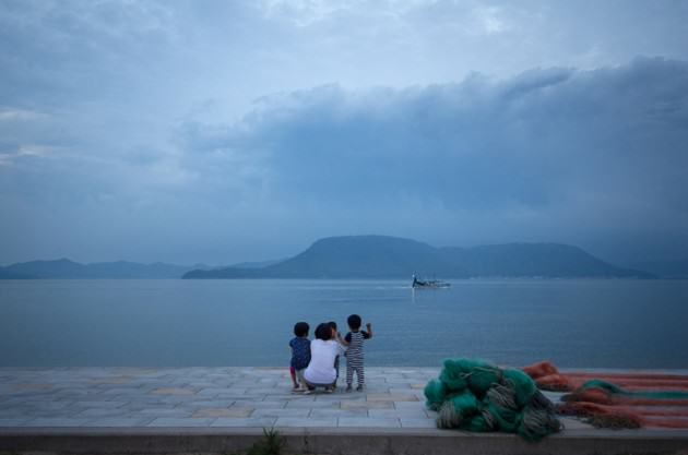 The only three children from the island wave to an incoming fishing boat. Photo: Patrick M. Lydon