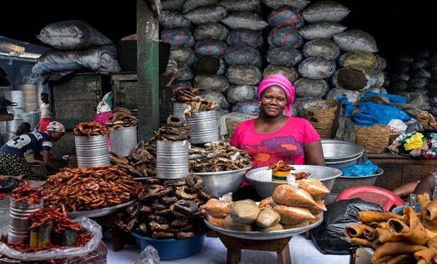 A person standing behind a table full of food