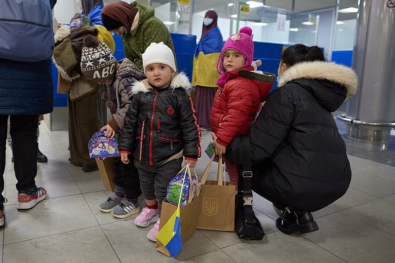 A group of children in a line at an airport