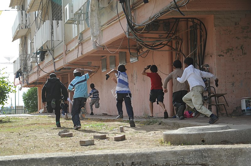 A group of children running outside beside a building