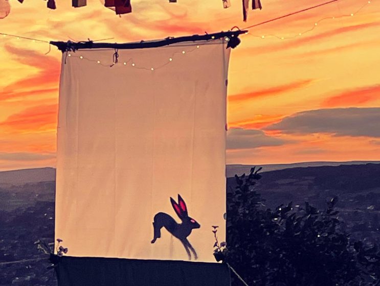 A picture of a screen printed with a rabbit against a sunseted sky