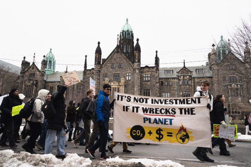 A picture of a large group of people holding a large banner reading "It's not investment if it wrecks the planet"