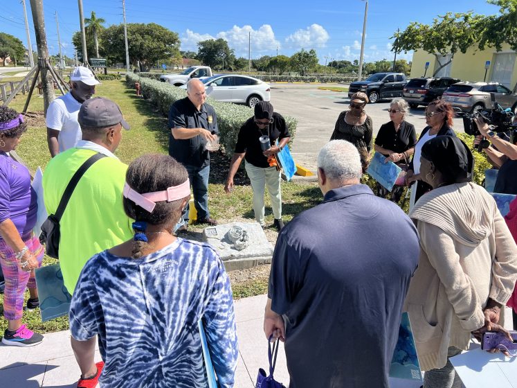 A picture of a group of people standing around a water drainage access