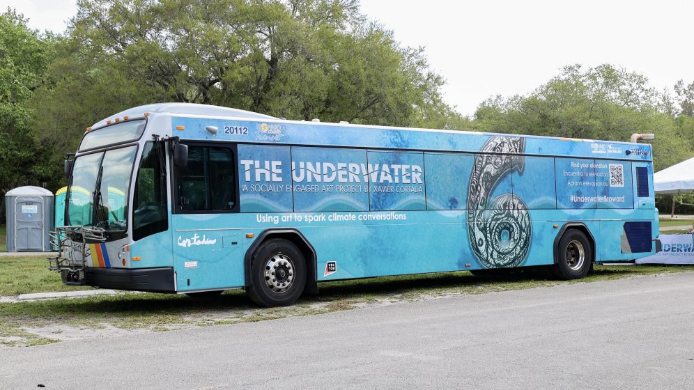 A picture of a blue bus painted with water and a large number 6 on the side of it