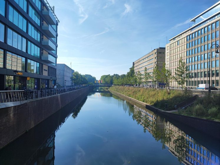 A picture of a river running along a canal next to a city